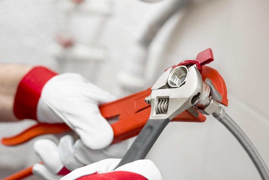 Plumber holding pipe wrenches for an emergency repair in Apollo Beach
