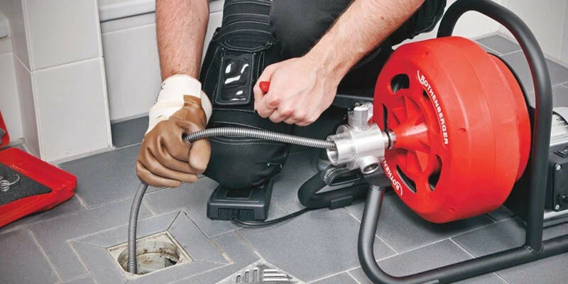 Plumber using a drain-cleaning machine in Apollo Beach