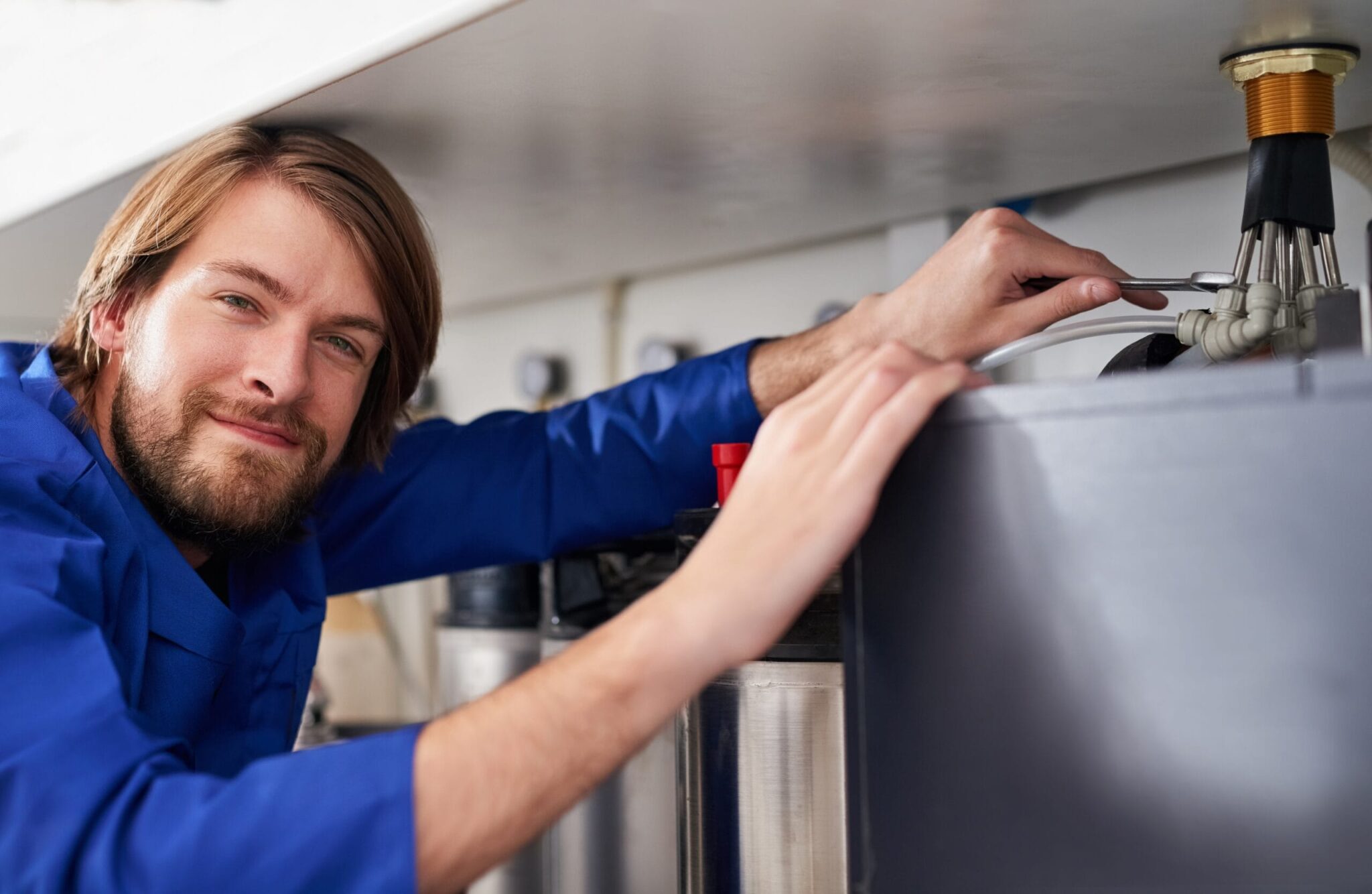Technician servicing a residential water heater tank in Apollo Beach