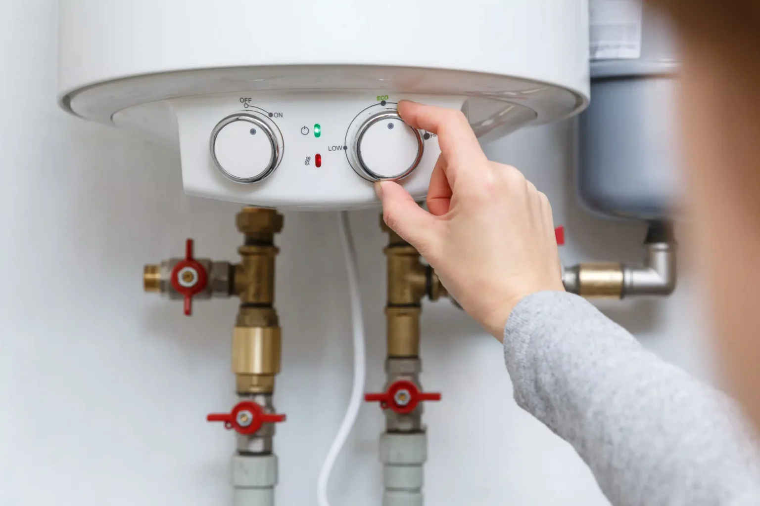 Homeowner adjusting the temperature controls on a water heater in Apollo Beach